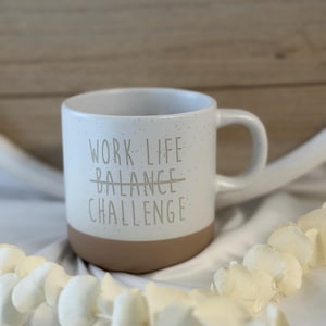 May include: A set of three ceramic mugs with a speckled, matte finish. The mugs are in shades of cream, light gray, and dark gray. Each mug has a simple, minimalist design, perfect for coffee or tea.