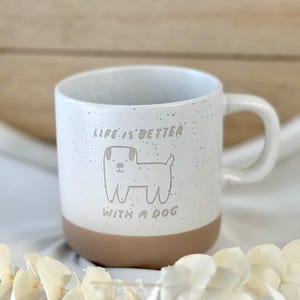 Könnte beinhalten: Eine weiße Keramik-Tasse mit schwarzem Henkel und dem Text "But First, Coffee" in handschriftlichem Stil. Die Tasse steht auf einer weißen Oberfläche. Die Tasse ist etwa 10 cm hoch.