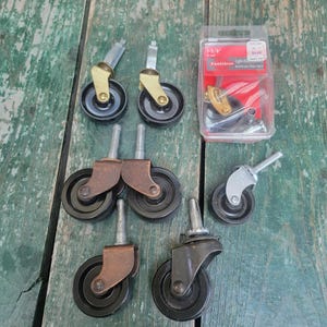May include: An assortment of furniture casters with black wheels and metal hardware. Some casters have brass or copper-colored accents. A package of casters is also included, with the text "1-5/8" and "Fasteners Light Duty".