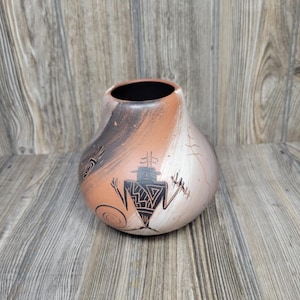 May include: A rounded terracotta pottery vase featuring a wide opening and a tapered neck. The surface displays a smooth matte finish with blended shades of tan, cream, and dark brown, decorated with black hand-painted geometric figures and lines.