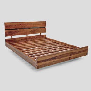 May include: A wooden bed frame with a headboard and a slatted base. The bed frame is made of a warm-toned wood with visible grain. The headboard has a horizontal design with a dark accent. The bed frame is designed for a standard mattress.