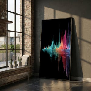 Op de afbeelding: Een ingelijste kunstdruk met een kleurrijk abstract ontwerp. Het kunstwerk toont een levendig spectrum aan kleuren, waaronder blauw, teal, roze en rood, tegen een zwarte achtergrond. Het ontwerp lijkt op een bergketen die in het water weerspiegeld wordt.