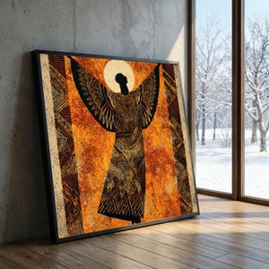 May include: Framed artwork featuring a stylized figure with outstretched arms and wings. The figure is depicted in black and gold patterns against an orange textured background. The artwork is leaning against a concrete wall and wooden floor.