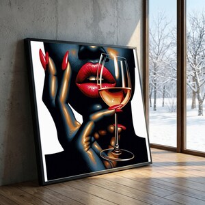 May include: Framed artwork depicting a stylized illustration of a person with red lipstick and nails holding a wine glass. The artwork is in a black frame and set against a neutral background.