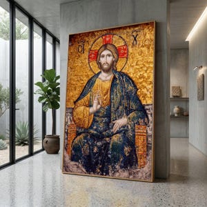 May include: A framed religious icon featuring a mosaic of a seated figure with a halo. The figure wears a blue and gold robe, set against a gold background. The artwork is displayed in a modern, minimalist interior.