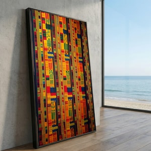 Könnte beinhalten: Ein gerahmtes Kunstwerk mit einem lebendigen, farbenfrohen Muster. Das Design integriert vertikale Streifen mit geometrischen Formen in Rot, Gelb, Grün und Blau. Das Kunstwerk lehnt an einer Betonwand, mit Blick auf das Meer und den Himmel im Hintergrund.