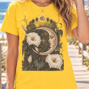 Könnte beinhalten: Ein leuchtend gelbes T-Shirt mit kurzen Ärmeln und einem Grafikdruck, der eine Mondsichel mit menschlichem Gesichtsprofil zeigt, umgeben von weißen Trichterwinden, dunkelgrünem Blattwerk, einem kleinen Schmetterling und einer Mondphasenanzeige.