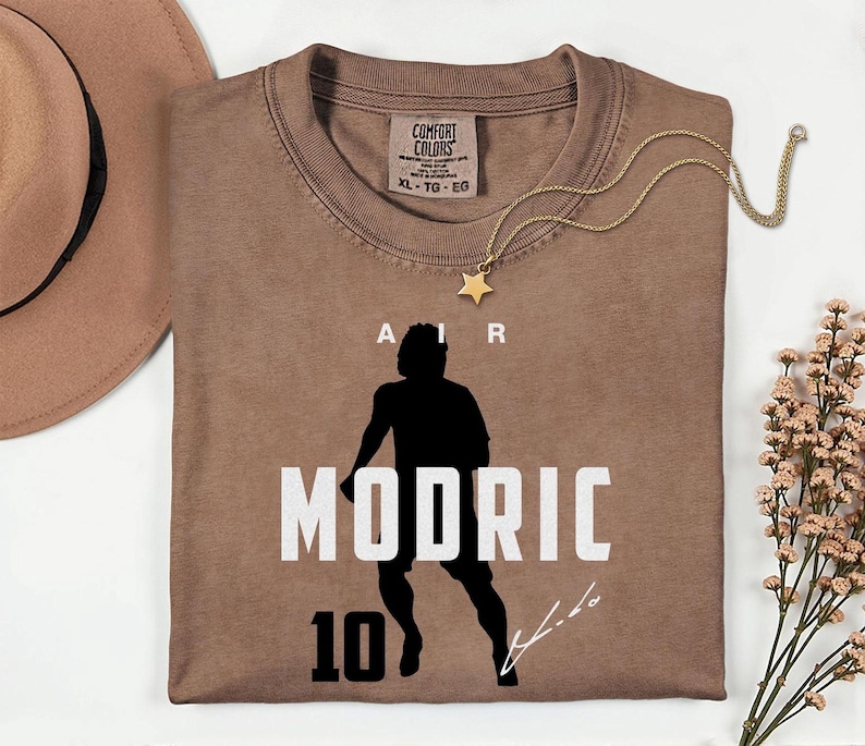 a brown t-shirt with a silhouette of a person and the text "MODRIC 10" printed on it.