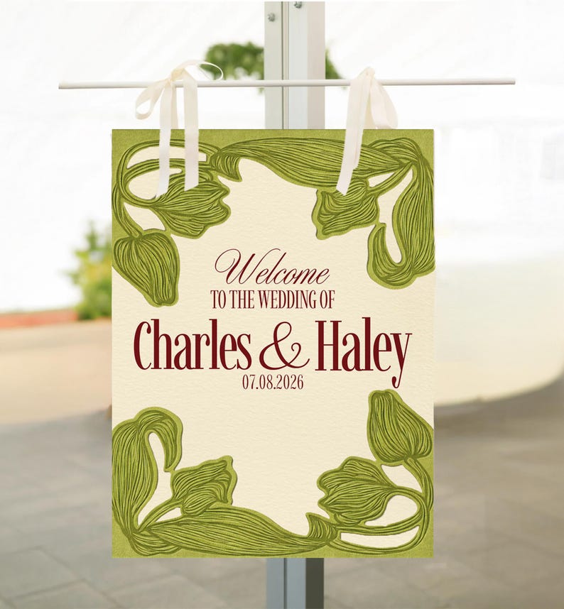 May include: A rectangular wedding welcome sign with a cream background and green floral border. The sign reads "Welcome TO THE WEDDING OF Charles & Haley 07.08.2026" in burgundy script. White ribbons are attached at the top for hanging.