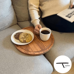 Könnte beinhalten: Eine weiße Keramik-Tasse mit schwarzem Henkel und dem Text "But First, Coffee" in fetter, schwarzer Schrift. Die Tasse ist mit einer dunklen Flüssigkeit, wahrscheinlich Kaffee, gefüllt und steht auf einer hellen Oberfläche.