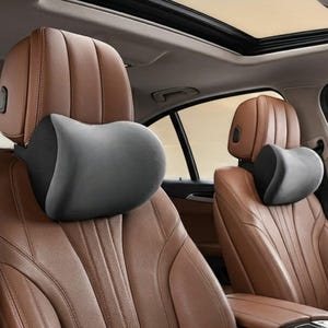 May include: Gray and black car headrest pillows. The headrests are designed to provide support and comfort. The car seats are brown leather. The car has a sunroof.
