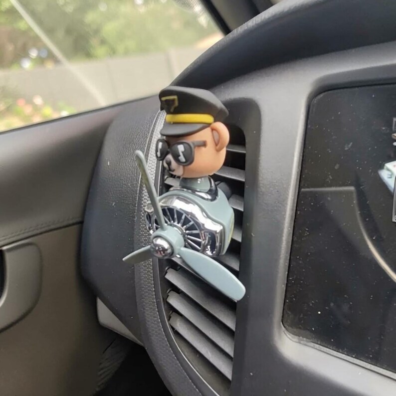 Airplane car air freshener with rotating propeller and pilot bear design, designed as a vent clip diffuser for car interiors. This decorative car accessory provides light fragrance while adding a fun aviation-inspired touch. Made from durable ABS material, it easily attaches to air vents and spins with airflow. Perfect for enhancing car decor and keeping your vehicle fresh during daily drives or road trips.
