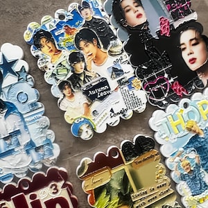 May include: A collection of rectangular acrylic charms featuring photographic portraits of K-pop artists, decorative text including "Autumn Leaves" and "Lonely," and colorful graphic elements with scalloped edges and pre-drilled holes for hanging.