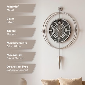May include: A silver metal wall clock measuring 50 x 90 cm with a circular frame, a dark clock face featuring a geometric pattern, and a cone-shaped pendulum. The clock uses a silent quartz battery-operated mechanism and displays the numbers 12, 3, 6, and 9.