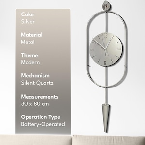 Pode incluir: Um relógio de parede de metal prateado com um mostrador circular exibindo os números 12 e 6, dentro de uma moldura oval. O relógio inclui uma haste vertical, um pêndulo e mede 30 x 80 cm. O texto à esquerda lista as especificações técnicas.