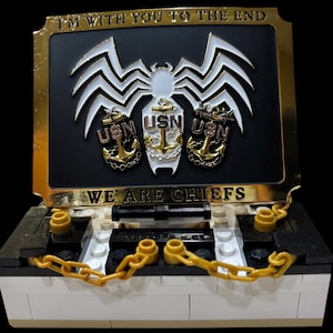 May include: A decorative box with a gold frame and the text "I'M WITH YOU TO THE END" and "WE ARE CHIEFS". The box features a white and silver spider design and three "USN" anchor emblems.
