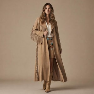 Puede incluir: Abrigo largo de ante color canela con flecos en las mangas y los laterales. El abrigo se lleva con una falda y botas a juego. El conjunto se complementa con un cinturón turquesa y una blusa blanca.