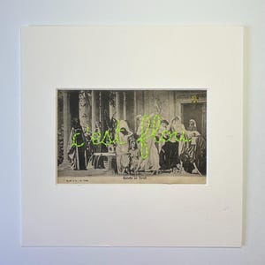 Peut inclure: Une impression encadrée en noir et blanc d'une scène historique, avec une broderie vert néon épelant les mots "cafe fleur". L'impression est montée sur un passe-partout blanc.