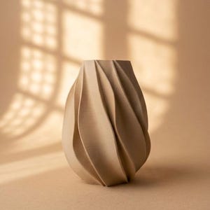 Può includere: Un vaso color beige con una distinta trama a coste a spirale che crea una serie di creste verticali e curve lungo l'esterno. L'oggetto presenta un collo affusolato e un corpo arrotondato più ampio, con una finitura opaca su tutta la superficie.