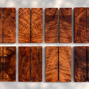 May include: Eight rectangular wooden blocks arranged in four pairs, each featuring distinct reddish-brown and dark brown wood grain patterns with swirling, wavy, and linear textures across their smooth, flat surfaces.