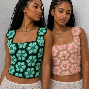 May include: Two sleeveless crochet tops featuring a hexagonal floral pattern. One top is crafted in shades of dark and light green, while the other is made in shades of pink and beige. Both garments have a square neckline and a cropped length.