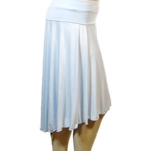 May include: A light blue skirt with a wide waistband and a flowing, asymmetrical hemline. The skirt is made of a soft, lightweight fabric, perfect for warm weather. The skirt's design is simple and elegant, suitable for various occasions.