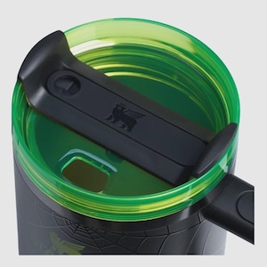 Puede incluir: Primer plano de un termo de viaje negro y verde. La tapa es negra con un peque&ntilde;o emblema y un cierre deslizante. El borde y el interior son de color verde transparente. El exterior del termo tiene un patr&oacute;n texturizado y un gr&aacute;fico verde.