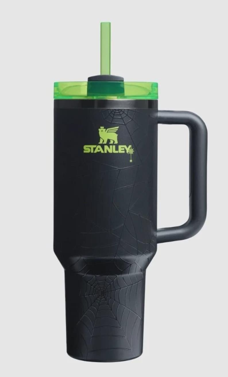 Puede incluir: Vaso Stanley negro con tapa y pajita verdes. El vaso presenta un dise&ntilde;o de telara&ntilde;a y el logotipo de Stanley en verde. Incluye un asa para facilitar su transporte.