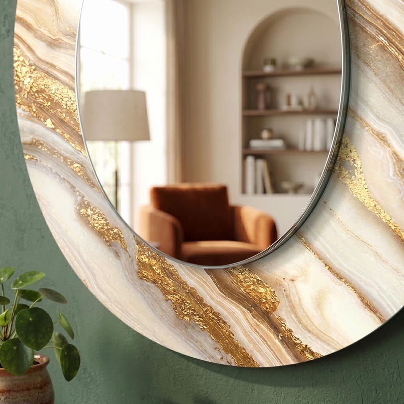 Peut inclure: Miroir ovale avec une bordure d&eacute;corative aux tons cr&egrave;me, or et marron, imitant le marbre. Le miroir a un fin cadre m&eacute;tallique argent&eacute;. Le reflet montre une pi&egrave;ce avec une chaise, une lampe et une biblioth&egrave;que.