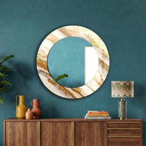 Peut inclure: Un miroir rond d&eacute;coratif avec un cadre effet marbre blanc, dor&eacute; et marron. Le centre du miroir est turquoise, avec une section blanche &agrave; droite. Il est accroch&eacute; &agrave; un mur turquoise au-dessus d'un meuble en bois.