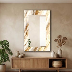Peut inclure: Miroir mural rectangulaire avec un cadre effet marbre aux tons dor&eacute;s et beiges. Le miroir est suspendu au-dessus d'un meuble en bois avec des vases et un panier tress&eacute;. Une plante en pot est visible &agrave; gauche.