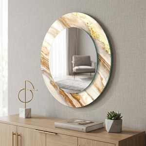 Peut inclure: Miroir d&eacute;coratif rond avec un motif effet marbre dans les tons de blanc, beige et or. Le miroir est fix&eacute; au mur au-dessus d'un meuble en bois. Le cadre a un effet de feuilles d'or.
