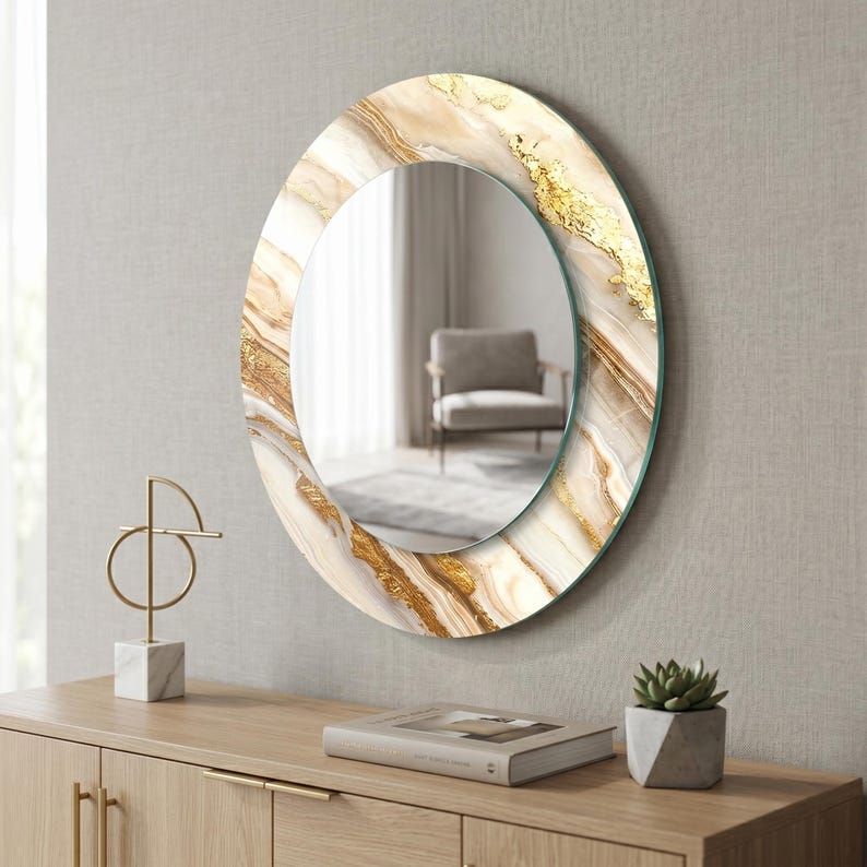 Peut inclure: Miroir d&eacute;coratif rond avec un motif effet marbre dans les tons de blanc, beige et or. Le miroir est fix&eacute; au mur au-dessus d'un meuble en bois. Le cadre a un effet de feuilles d'or.