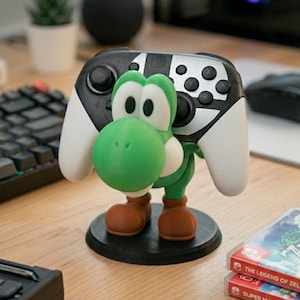 Soporte universal para mandos de Nintendo Switch, PlayStation, XBOX o PC inspirado en Yoshi, el personaje de Mario Bros, ideal para regalo de cumpleaños original tanto para niños como para mayores gamers.