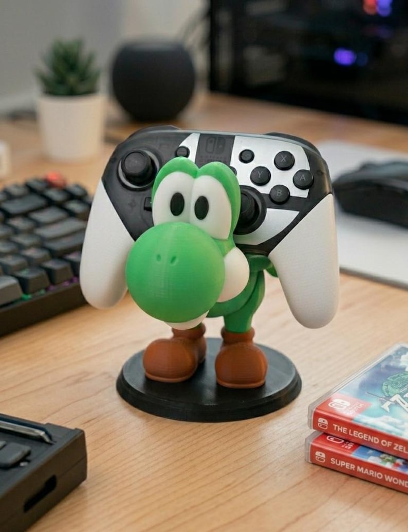 Soporte universal para mandos de Nintendo Switch, PlayStation, XBOX o PC inspirado en Yoshi, el personaje de Mario Bros, ideal para regalo de cumpleaños original tanto para niños como para mayores gamers.