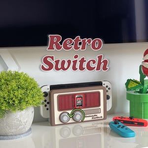 Può includere: Una console Nintendo Switch bianca inserita in una base di ricarica in stile radio retrò color marrone e crema. Il dock presenta due manopole circolari, una griglia rossa per altoparlanti e uno slot centrale per cartucce. Testo Retro Switch.
