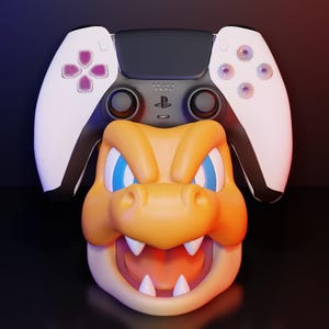 Może przedstawiać: Obraz wyrenderowany w 3D przedstawiający kontroler PlayStation 5 spoczywający na szczycie kreskówkowej pomarańczowo-żółtej głowy smoka. Kontroler ma białe boki z fioletowymi akcentami przycisków. Smok ma niebieskie oczy i otwartą paszczę.