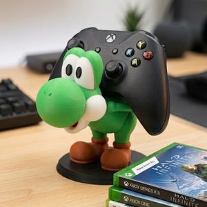 Soporte universal para mandos de Nintendo Switch, PlayStation, XBOX o PC inspirado en Yoshi, el personaje de Mario Bros, ideal para regalo de cumpleaños original tanto para niños como para mayores gamers.