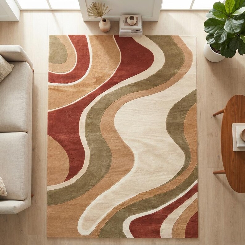 May include: A rectangular area rug featuring a wavy, organic pattern in shades of terracotta red, olive green, tan, and cream. The design consists of flowing, curved bands that span the entire surface of the rug, creating a rhythmic, layered effect.
