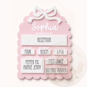 May include: A light pink scalloped sign with a white bow at the top. It features the name Sophia and text including My First Day Of: Reception, My Age: Four, My Height: 103cm, The Date: 6.9.26, Things I Love: Pepper Pig, Auntie Jenny, My Teacher Is: Miss Lowse, and I Want To Be A: Dolphin Trainer.