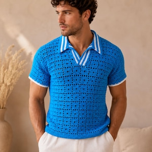 Può includere: Una polo blu brillante a maniche corte con un design all'uncinetto. La camicia presenta colletto e bordi delle maniche bianchi, con due strisce bianche sul colletto. Viene abbinata a pantaloni bianchi.