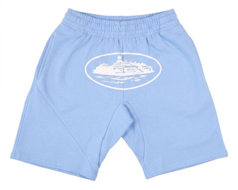 K&ouml;nnte beinhalten: Hellblaue Shorts mit elastischem Bund und Seitentaschen. Auf der Vorderseite ist ein wei&szlig;es ovales Motiv mit einem Geb&auml;ude und Wasser aufgedruckt. Die Shorts sind aus weichem Material.