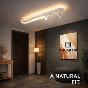 May include: White modern ceiling light fixture with integrated LED lighting and adjustable spotlights. The fixture is mounted on a dark ceiling. The image also includes a painting, a floor lamp, and the text "A NATURAL FIT."