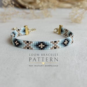May include: A beaded loom bracelet featuring a geometric pattern in shades of light blue, black, white, and metallic gold. The bracelet includes gold-tone metal end caps and a clasp. Text on the image reads: LOOM BRACELET PATTERN PDF INSTANT DOWNLOAD.