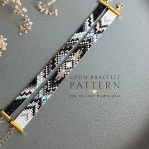 May include: Two loom bracelets featuring a geometric pattern in black, white, light blue, and metallic gold beads. Each bracelet is finished with gold-toned metal end caps and lobster claw clasps. The text reads LOOM BRACELET PATTERN PDF INSTANT DOWNLOAD.