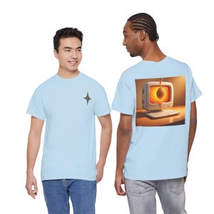 Puede incluir: Camisetas de color azul claro. Una tiene un gráfico de estrella, la otra un gráfico de ordenador en la espalda. El gráfico del ordenador muestra un monitor retro con un cucharón de miel y un panal. Las camisetas son de material suave.