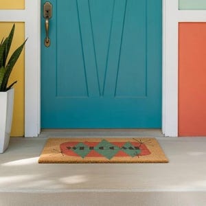 May include: A teal front door with a decorative design and a welcome mat. The door is framed by walls painted in yellow, orange, and mint green. A white planter with a green plant sits to the left of the door.