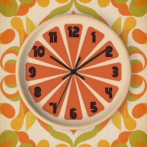 May include: A retro-style wall clock with an orange slice design. The clock face features orange segments with black numerals and hands. The clock is set against a patterned background with orange, yellow, and green floral motifs, and has a light wood frame.