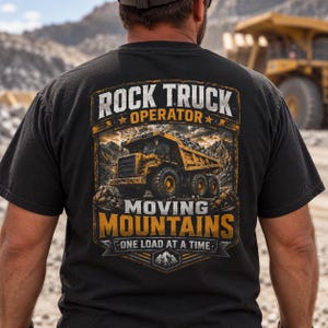 May include: A black t-shirt featuring a graphic on the back with a yellow dump truck in a mountain landscape. The text reads: ROCK TRUCK OPERATOR MOVING MOUNTAINS ONE LOAD AT A TIME. The design uses yellow, white, and grey colors with a rugged aesthetic.