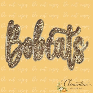 Puede incluir: Un diseño de guión "Bobcats" con lentejuelas doradas sobre un fondo amarillo. El texto está en un estilo cursivo, con cada letra delineada individualmente con lentejuelas doradas. El diseño es probablemente para ropa o accesorios.